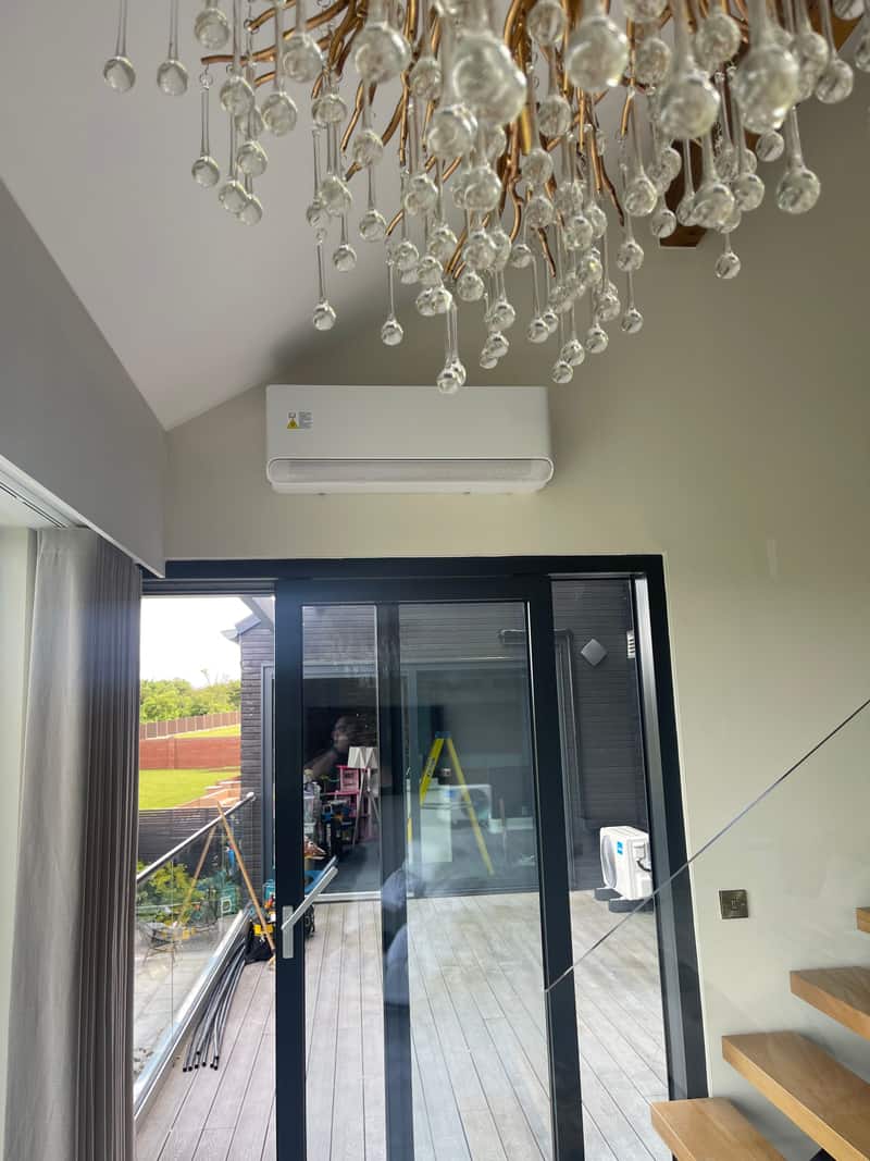 Garden room aircon install, Newcastle upon Tyne Wall-mounted air conditioner above sliding doors in a Newcastle upon Tyne garden room